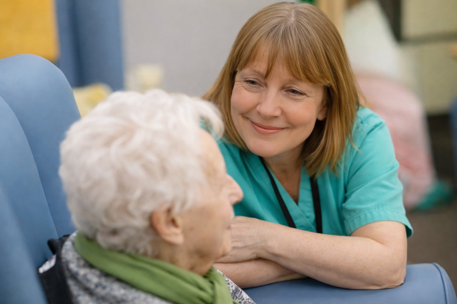 Care professional speaking with an older adult in a living room